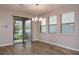 Dining area with wood-look flooring, sliding door access to an outdoor patio, and large windows at 210 Wooded Vine Dr, Winter Springs, FL 32708