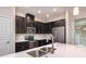 Close-up of a well-equipped kitchen with stainless steel appliances, dark cabinets, and a white countertop at 210 Wooded Vine Dr, Winter Springs, FL 32708