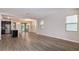 Open-concept living area with wood-look tile flooring, leading to a modern kitchen with stainless steel appliances at 210 Wooded Vine Dr, Winter Springs, FL 32708