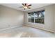 Bedroom with neutral carpet, ceiling fan, and a large window overlooking backyard at 2700 Child St, Ocoee, FL 34761