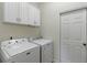 Functional laundry room featuring a washer, dryer, and ample storage cabinets at 2700 Child St, Ocoee, FL 34761