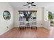 Bright living room with wood floors, ceiling fan, and two chairs with accent table at 2700 Child St, Ocoee, FL 34761