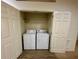 Laundry closet featuring a white washer and dryer, and open doors at 2952 Ashland S Ln, Kissimmee, FL 34741