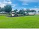 Community playground featuring swings, slide and climbing structure with well maintained green space on a sunny day at 2952 Ashland S Ln, Kissimmee, FL 34741