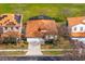 Aerial view of a beautiful home with a red tile roof, screened-in pool, and lush green surroundings at 304 Summer Place Loop, Clermont, FL 34714