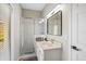 Bathroom featuring quartz countertops, white vanity, framed mirror, tile floors, and glass shower at 304 Summer Place Loop, Clermont, FL 34714