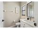 A bathroom features white cabinetry, a black framed mirror, a window, and a tiled shower at 304 Summer Place Loop, Clermont, FL 34714