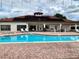 Community pool area with chairs and tables in a luxurious setting, adjacent to the clubhouse at 304 Summer Place Loop, Clermont, FL 34714