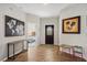 Inviting foyer featuring wood-look tile flooring and decorative wall art and leads to a bedroom at 304 Summer Place Loop, Clermont, FL 34714