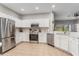 Eat-in kitchen featuring stainless steel appliances, white cabinetry and tile flooring at 304 Summer Place Loop, Clermont, FL 34714