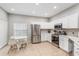 Eat-in kitchen with stainless steel appliances, white cabinetry and tile flooring at 304 Summer Place Loop, Clermont, FL 34714