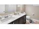 Bathroom featuring double sinks, dark wood cabinets, and a Mickey Mouse rug at 3136 Winesap Way, Winter Garden, FL 34787