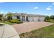 Front exterior showcasing a three-car garage and a brick driveway at 3136 Winesap Way, Winter Garden, FL 34787