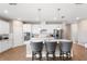 Modern kitchen with an island featuring bar stool seating, stainless steel appliances, and white cabinetry at 3136 Winesap Way, Winter Garden, FL 34787