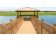 A serene lakeside wooden dock with a gazebo offering a tranquil escape and beautiful views at 3197 Pequod Pl, Kissimmee, FL 34746