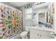 Bright bathroom featuring a colorful shower curtain, white vanity with a stone countertop, and decorative turtle accents at 3430 Halsway Dr, Orlando, FL 32824