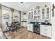 Bright kitchenette with granite countertops, white cabinets, bar table, and modern stainless steel beverage cooler at 3430 Halsway Dr, Orlando, FL 32824