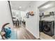 Entry with laundry room featuring modern washer and dryer, shelving and view of open floorplan with staircase at 3430 Halsway Dr, Orlando, FL 32824