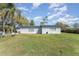 Green backyard showcasing a well-maintained lawn and the rear exterior of the home at 395 Bearcreek Dr, Bartow, FL 33830