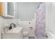 Compact bathroom with a unicorn shower curtain, white tile, and vanity, offering a functional layout at 395 Bearcreek Dr, Bartow, FL 33830