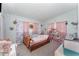 Bedroom features a platform bed, toy furniture, and pink curtains for a colorful room at 395 Bearcreek Dr, Bartow, FL 33830