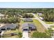 An aerial view shows the house sitting on a lot with other similar homes and a wooded area in the background at 4016 Sw 151 Street, Ocala, FL 34473