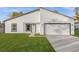 Bright single-story home featuring a minimalist design, attached garage, and green lawn at 4016 Sw 151 Street, Ocala, FL 34473