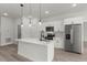 Modern kitchen featuring a center island with pendant lights, white cabinets and stainless steel appliances at 4016 Sw 151 Street, Ocala, FL 34473