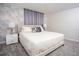 Cozy bedroom featuring a plush bed, modern wallpaper, neutral colors, and soft lighting at 432 Ocean Course Ave, Davenport, FL 33896