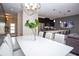 Elegant dining room with a white table, leather chairs, and a view into the modern kitchen at 432 Ocean Course Ave, Davenport, FL 33896