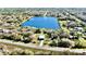 Stunning aerial view of a modern home near a serene lake, surrounded by lush greenery and a peaceful neighborhood at 4501 Dallas Blvd, Orlando, FL 32833