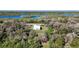 Aerial view of a modern home surrounded by lush trees and a beautiful blue lake, showcasing its secluded location at 4501 Dallas Blvd, Orlando, FL 32833