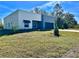 A modern home is surrounded by lush landscaping and features an attached two car garage at 4501 Dallas Blvd, Orlando, FL 32833