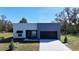 Modern style home with a spacious two-car garage, gray and white facade, and manicured landscaping at 4501 Dallas Blvd, Orlando, FL 32833