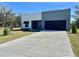 Newly built home featuring a wide driveway, a modern design, and a blue sky backdrop at 4501 Dallas Blvd, Orlando, FL 32833