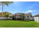 Spacious backyard featuring a screened lanai, well-maintained lawn, and white picket fence at 4963 Rock Rose Loop, Sanford, FL 32771