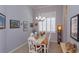 Dining room with a wooden table, and a chandelier, lit by a large window at 4963 Rock Rose Loop, Sanford, FL 32771