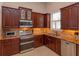 Renovated kitchen featuring stainless steel appliances, granite countertops, and dark wood cabinetry at 4963 Rock Rose Loop, Sanford, FL 32771