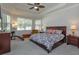 Spacious primary bedroom featuring a tray ceiling, ceiling fan, and a bay window at 4963 Rock Rose Loop, Sanford, FL 32771