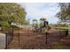 Community playground with slides and climbing structures surrounded by a black fence and trees at 4963 Rock Rose Loop, Sanford, FL 32771