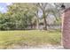 Fenced backyard with green grass and scattered trees with dappled sunlight at 5042 Downing St # 5, Orlando, FL 32839