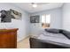 Cozy bedroom with a window, dark wood dresser, ceiling fan and a cool comic wall art at 5042 Downing St # 5, Orlando, FL 32839