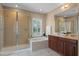 Bright bathroom featuring a walk-in shower, soaking tub, and double vanity with dark wood cabinets at 5189 Fenwood Ln, Orlando, FL 32814