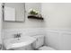 Stylish powder room with elegant wainscoting, pedestal sink, and decorative shelf at 5189 Fenwood Ln, Orlando, FL 32814