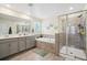 Bathroom featuring double sinks, bathtub, walk-in shower, neutral tiling, and modern fixtures at 5269 Red Coral Cir, Mount Dora, FL 32757