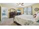 Bright bedroom with a ceiling fan, plush carpet, and a large window with backyard views at 5269 Red Coral Cir, Mount Dora, FL 32757