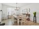 Bright dining room with wood-look tile flooring, a chandelier, a dining table, and natural light at 5269 Red Coral Cir, Mount Dora, FL 32757
