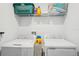 Laundry room with a white washer and dryer with storage shelf above at 5269 Red Coral Cir, Mount Dora, FL 32757