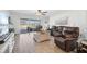 Comfortable living room with wood-look tile flooring, a ceiling fan, leather furniture, and sliding glass doors at 5269 Red Coral Cir, Mount Dora, FL 32757