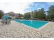 A spacious swimming pool surrounded by brick pavers, seating, and beautiful landscaping creates an inviting outdoor oasis at 5269 Red Coral Cir, Mount Dora, FL 32757